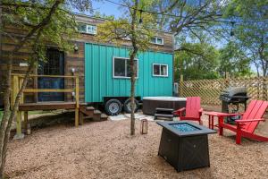 a green tiny house with a table and chairs at Stunning Modern Tiny Home with Grill in Fredericksburg