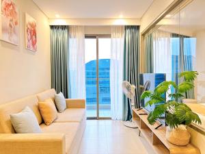 a living room with a couch and a large window at The Song Vung Tau Apartment in Vung Tau