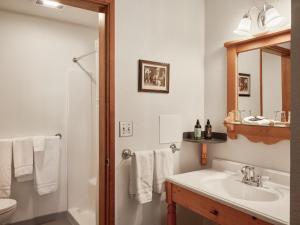 een badkamer met een wastafel, een toilet en een spiegel bij Hotel Pension Anna in Leavenworth