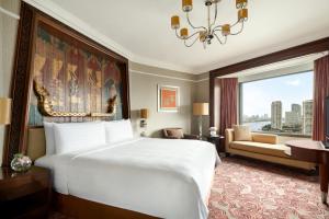 a bedroom with a large bed and a large window at Shangri-La Bangkok in Bangkok