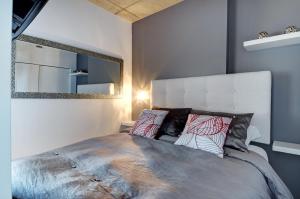 1 dormitorio con 1 cama grande y espejo en Les Immeubles Charlevoix - Le 760514, en Quebec