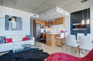 a living room with a white couch and a kitchen at Les Immeubles Charlevoix - Le 760514 in Quebec City