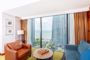 a living room with a room with a large window at Hampton by Hilton Zhuhai Gongbei Port in Zhuhai