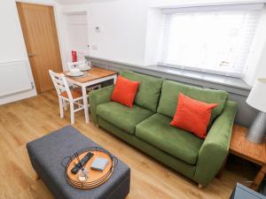 a living room with a green couch and a table at Star Cottage in Saundersfoot +12 photos