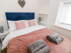 a bedroom with a bed with two towels on it at Star Cottage in Saundersfoot