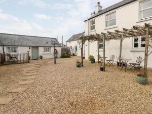 a patio with a table and chairs in front of a house at Star Cottage in Saundersfoot