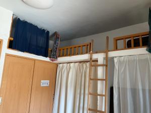 ゲストハウスKOIZUMI في Oshima: غرفة مع سرير بطابقين وسلم