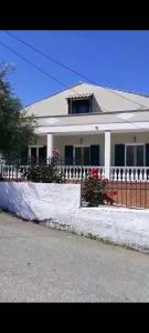 a white house with a fence in the snow at Kouros apartment, Agios Nikolaos, Petriti in Ágios Nikólaos