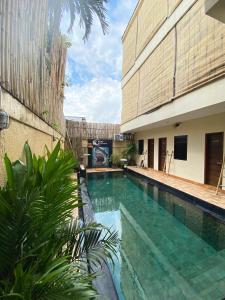 a swimming pool in front of a building at Kent Beach House in Canggu