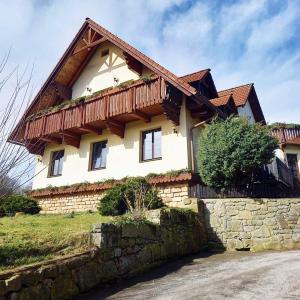 a house with a wooden roof and a stone wall at Naruby Ubytování in Mařov u Úpice