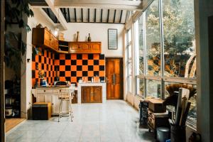a kitchen with a checkerboard pattern on the wall at Omah Bagelen Homestay 