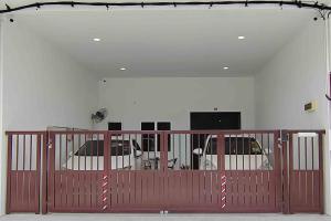 una puerta roja en una habitación con dos coches aparcados en New Single Storey Homestay @ Sitiawan 3R2B (6-9PAX) _Feb Moment Homestay, en Sitiawan