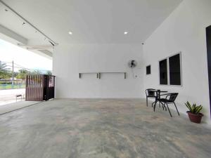 New Single Storey Homestay @ Sitiawan 3R2B (6-9PAX) _Feb Moment Homestay في سيتياوان: غرفة بيضاء مع كرسيين وطاولة