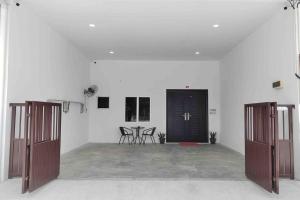 實兆遠的住宿－New Single Storey Homestay @ Sitiawan 3R2B (6-9PAX) _Feb Moment Homestay，一间白色的大房间,设有两扇门和椅子