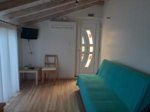 salon z zieloną kanapą i oknem w obiekcie kedros w Elafónisos