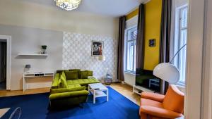 a living room with a green couch and orange chairs at Great Synagogue Apartment, 2 separate bedrooms, 5 guests, Fast Wifi,AC in Budapest