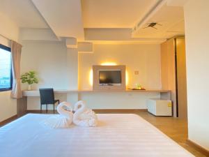 two white wedding shoes sitting on the floor of a room at View Dee BKK Airport Residence in Ban Khlong Prawet