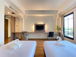 2 cygnes sur 2 lits dans une chambre d'hôtel dans l'établissement View Dee BKK Airport Residence, à Ban Khlong Prawet