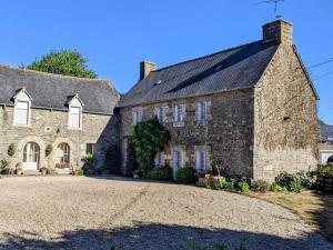 una antigua casa de piedra con una gran entrada en Breizh home A la Boissière, en Merléac