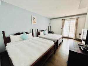 a bedroom with two beds and a window at 墾丁儷庭民宿Li Ting B&B in Kenting