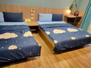 2 Betten in einem Hotelzimmer mit einer Pandabdecke in der Unterkunft Long Quan Ju in Wenquan