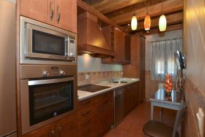 a kitchen with a microwave oven and a sink at Apartamentos La Casa Del Grial in Toledo