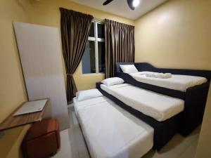 a hotel room with two beds and a table at Eid2 SKS Habitat Larkin-3BR Family Friendly up to 10Pax - 9 Beds- Free Wifi Pool Parking Gym & Preminum facilities in Johor Bahru