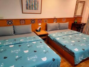 2 Betten nebeneinander in einem Zimmer in der Unterkunft Long Quan Ju in Wenquan