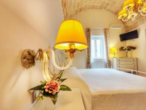 una camera da letto con un letto con una lampada e fiori su un tavolo di Palazzina Cavour a Monopoli