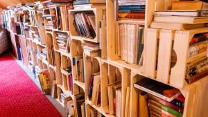 une rangée d'étagères dans une bibliothèque dans l'établissement Penzion Pod Houskou, à Blatce