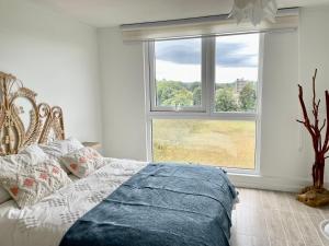 ein Schlafzimmer mit einem Bett und einem großen Fenster in der Unterkunft Nuevo y Cómodo depto tipo Estudio in Valdivia