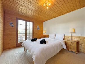 a bedroom with a large white bed in a wooden room at Chalet Albarose - Vercorin in Vercorin