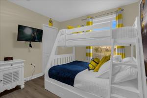- un lit superposé blanc avec des oreillers jaunes dans une chambre dans l'établissement 5 Bedrooms - 4,5 Bathrooms - Champions Gate 1404 Mv, à Orlando