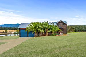 a house with palm trees in front of it at Acreage Home in The Heart of Hunter Valley in Ellalong