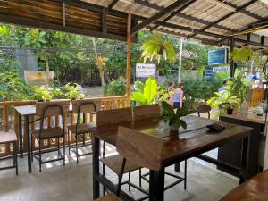 een restaurant met een tafel, stoelen en planten bij Sweed Dee Hostel in Phi Phi Don