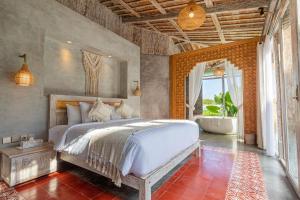 a bedroom with a bed and a tub in it at Casa Batu Belig in Seminyak