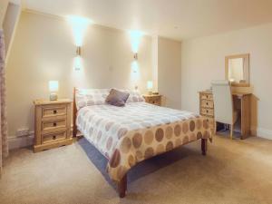 um quarto com uma cama, uma cómoda e um espelho em The Queens Inn em St Martin Guernsey