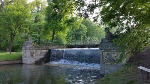 uma ponte de pedra sobre um lago com uma fonte em Appartement beim Schloss 