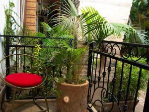 a balcony with a red chair and some plants at Green Villa Apartments in Kampala