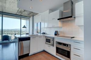 a kitchen with white cabinets and a large window at Les Immeubles Charlevoix - Le 760531 in Quebec City