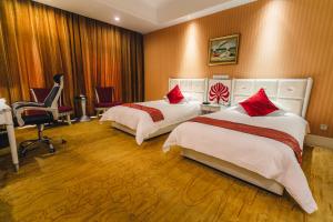 a hotel room with two beds and a chair at Suning Universal Hotel in Pukou