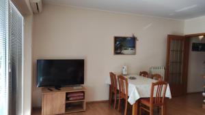 una sala da pranzo con tavolo e TV di Apartments Tomišić a Capodistria