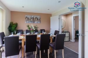 a dining room with a table and chairs at Syster Properties Serviced Accommodation Leicester 5 Bedroom House Glen View in Leicester