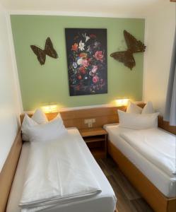2 camas en una habitación con mariposas en la pared en Europa Hotel City, en Saarbrücken