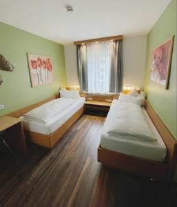 two beds in a room with a window at Europa Hotel City in Saarbrücken