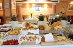 a table topped with lots of different types of bread and pastries at Hotel Rex in Belgrade