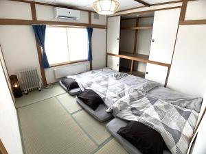 a bedroom with two beds and a window at Higashikawa home in Higashikawa