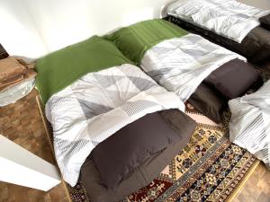 a pile of pillows sitting on top of a rug at Higashikawa home in Higashikawa
