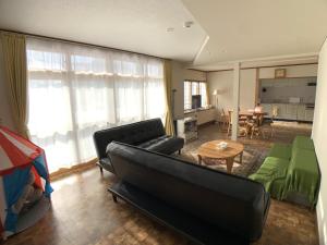 een woonkamer met een bank en een tafel bij Higashikawa home in Higashikawa