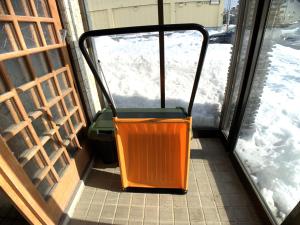 an orange chair sitting in front of a door at Higashikawa home in Higashikawa
